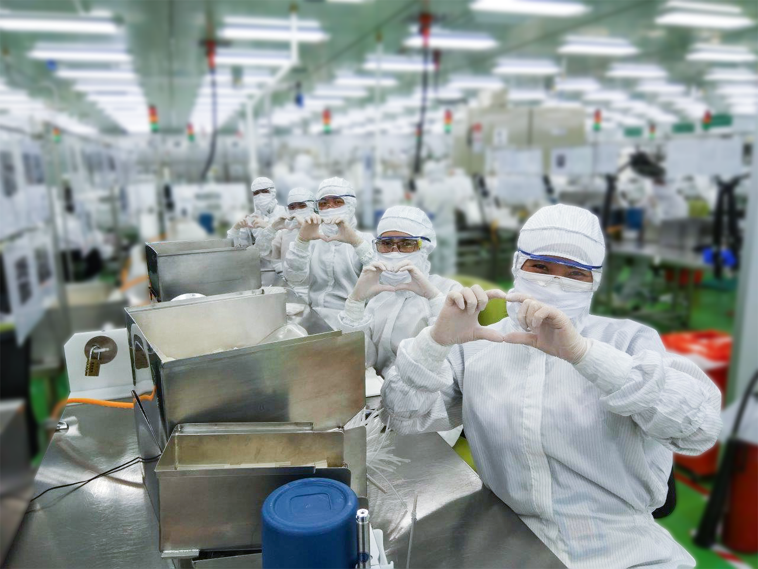 factory workers making a heart symbol with their hands